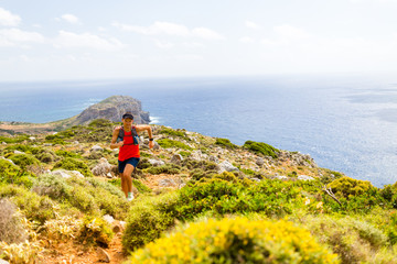 Happy trail running man in inspirational mountains