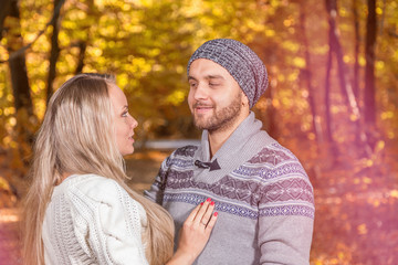 Young couple in love looking at each other in autumn park vintage stylized