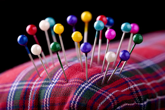 macro colored sewing pins in scottish pincushion