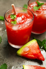 Cold watermelon drinks in glasses, on dark background