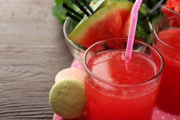 Cold watermelon drinks in glasses, on wooden table background