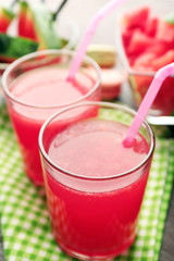 Cold watermelon drinks in glasses, on wooden table background