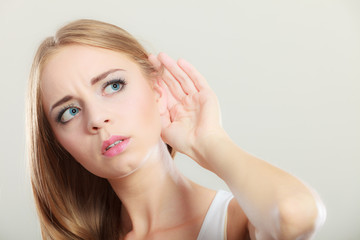 Fototapeta premium Woman with hand behind ear spying