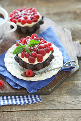 Sweet cakes with raspberries on wooden table background
