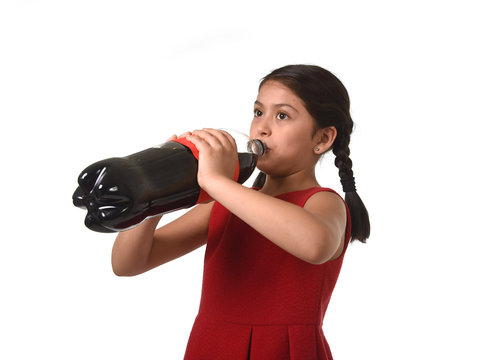 happy female child holding big soda cola bottle drinking in sugar drink abuse