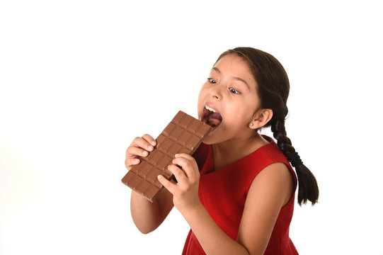 female child holding chocolate eating in happy excited face expression in sugary nutrition