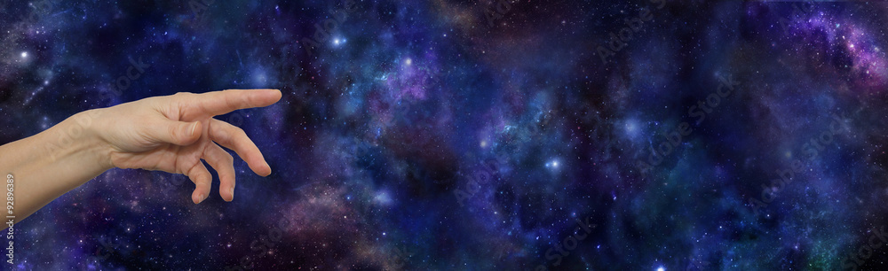 Wall mural the vastness of our universe - female hand pointing out to the vast open outer space night sky provi