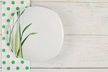 Empty stylish plate  on white rustic wooden background. Restaurant menu design concept