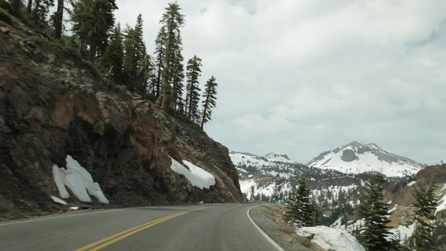 Driving on Lassen Peak Highway, with Lassen Peak in view, in Lassen Volcanic National Park, California in late Spring / early Summer.