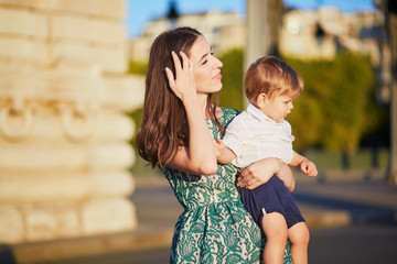 Fototapeta premium Beautiful young mother with her adorable in Paris, France