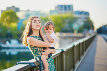 Fototapeta na wymiar Beautiful young mother with her adorable in Paris, France