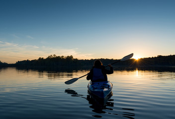 Naklejka na ściany i meble Woman Kayaking at Sunset