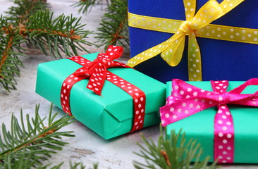 Wrapped gifts for Christmas and spruce branches on old plank