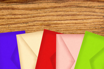 Color letters envelopes on wooden texture close-up