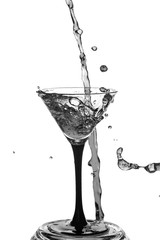 Cocktail glass with splashes on white background.