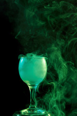 Green smoke in the glass. Halloween.