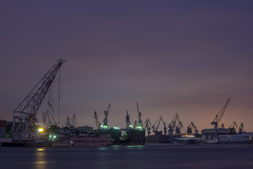Fototapeta na wymiar Night view on a cranes in the dock, near Neva river.