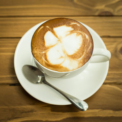Hot latte art coffee cup on table, vintage and retro style.