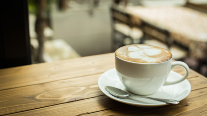 Hot latte art coffee cup on table, vintage and retro style.