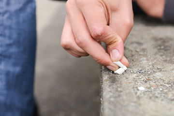 Hand of a young man extinguish cigarette on a stair
