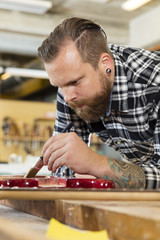 Man working at workshop with musical instruments