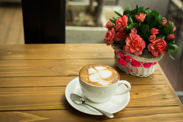 Hot latte art coffee cup on table, vintage and retro style.