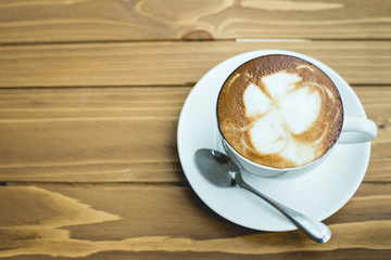 Hot latte art coffee cup on table, vintage and retro style.