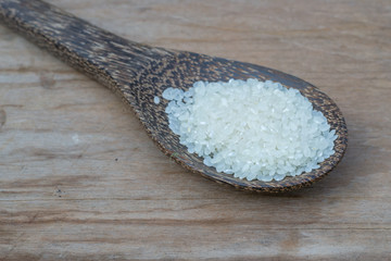 rice in wood spoon on wood background