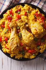 Spanish paella with chicken and vegetables closeup. vertical top view
