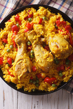 Spanish paella with chicken and vegetables closeup. vertical top view
