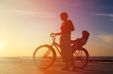 Obraz premium Silhouette of mother and baby biking at sunset