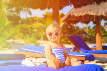 Obraz na płótnie Canvas cute little baby girl with seashells on tropical beach