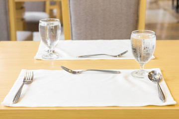 Glass of water on table setting for dining. 