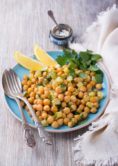 Chickpeas with zucchini and herbs on a wooden surface