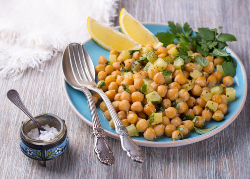 Chickpeas with zucchini and herbs on a wooden surface