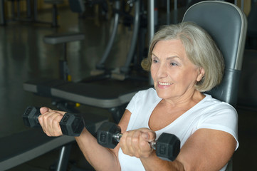 Fototapeta na wymiar Elderly woman exercising in gym