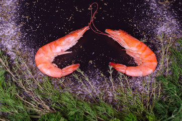 Two shrimps forming a heart with rosemary, salt and pepper