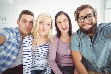 Obraz premium Smiling business people gesturing while taking selfie 