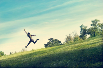 Fototapeta na wymiar woman running and jumping funny relax on green grass and flowers