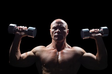 Obraz na płótnie Canvas Portrait of man exercising with dumbbells
