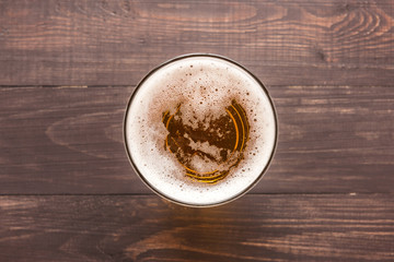 glass of beer on a wooden background. Top view