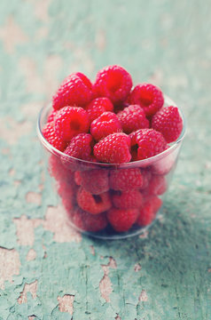 raspberry in a glass bowl on wooden surface