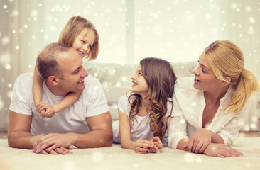 smiling parents and two little girls at home