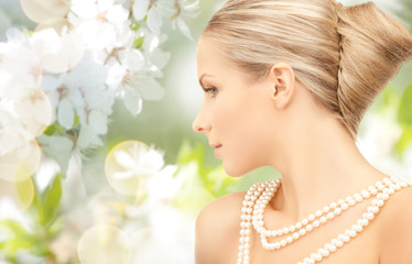 Obraz na płótnie Canvas woman with pearl necklace over cherry blossom