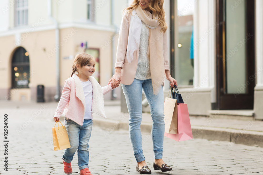 Wall mural happy mother and child with shopping bags in city