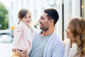 happy family with child and shopping bags in city