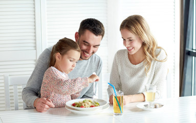 Obraz na płótnie Canvas happy family having dinner at restaurant or cafe