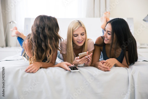 Три подруги на диване развлекаются на диване