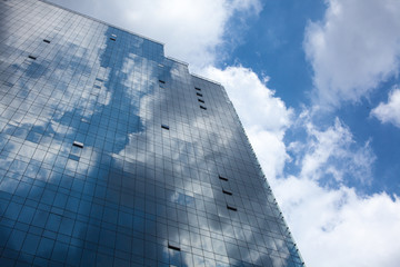 Plakat Abstract glass building reflecting clouds and blue sky