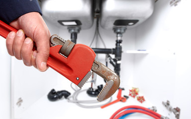 Hand of plumber with wrench.